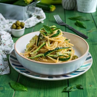 Pasta con le zucchine a julienne, formaggio grattugiato e foglie di basilico fresco