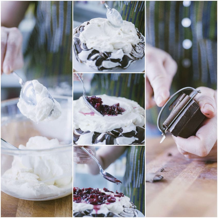 Panna montata versata sulla pavlova con ciliegie scure e scaglie di cioccolato grattugiate a mano