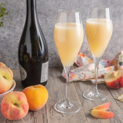 Bellini servito in due flute con purea di pesca fresca e spumante