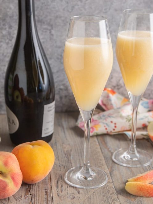 Bellini servito in due flute con purea di pesca fresca e spumante