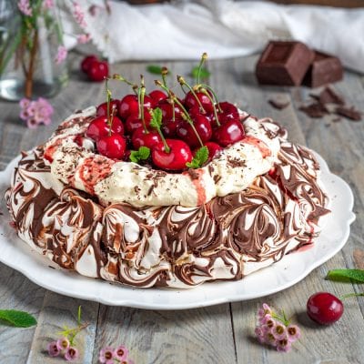 Pavlova foresta nera con meringa marmorizzata al cioccolato, panna montata e ciliegie fresche