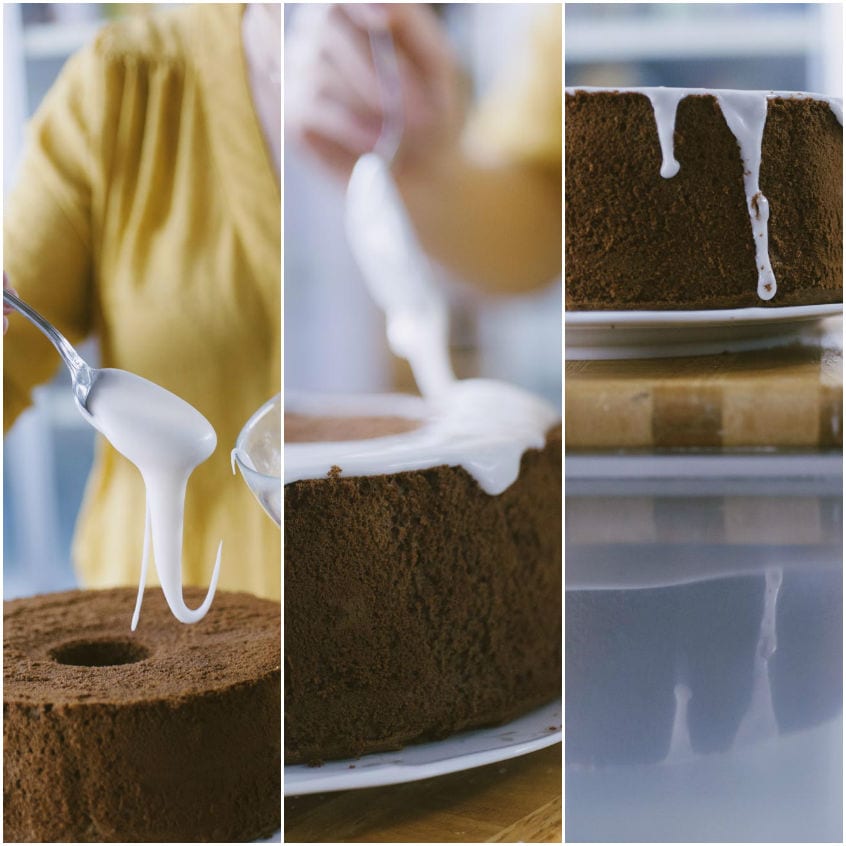 Glassa bianca versata a cucchiaiate sulla chiffon cake al cacao, che cola lungo i bordi