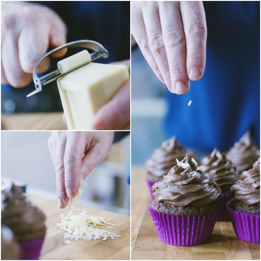 Scaglie di cioccolato bianco grattugiate e sparse sui cupcake al cioccolato con frosting a spirale