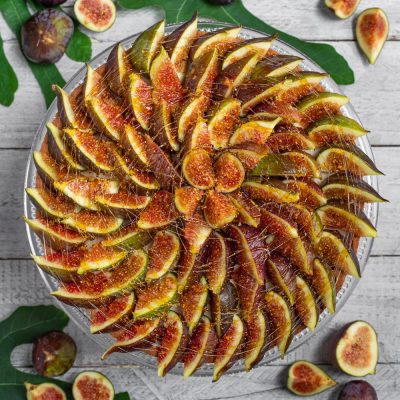 Crostata di ricotta e fichi con spicchi disposti a spirale e filo di miele