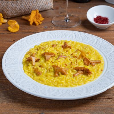 Risotto finferli e zafferano cremoso, guarnito con pistilli di zafferano e funghi saltati