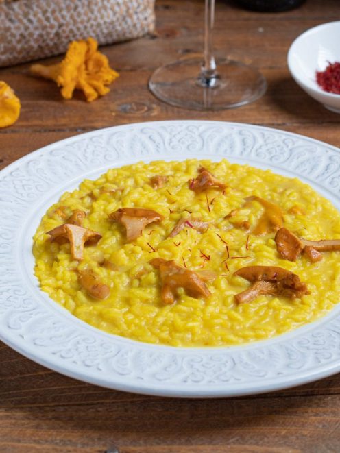 Risotto finferli e zafferano cremoso, guarnito con pistilli di zafferano e funghi saltati
