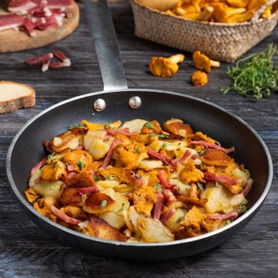Rosticciata di finferli e speck in padella con patate rosolate e timo fresco