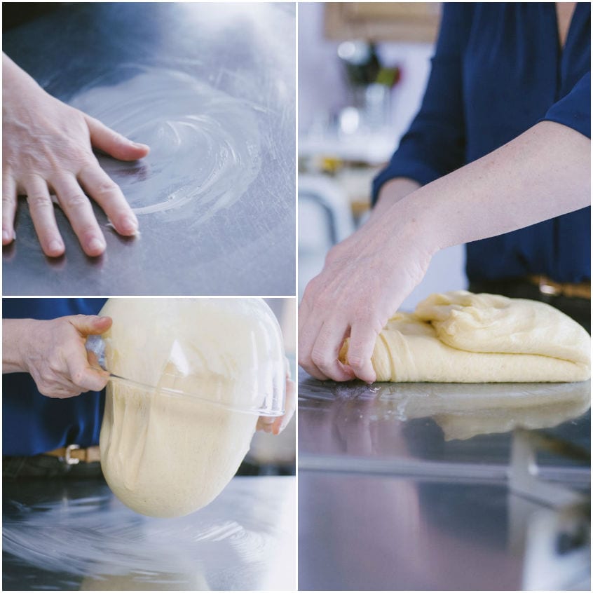 Mani che eseguono le pieghe sull'impasto morbido per le fette biscottate sul piano di lavoro