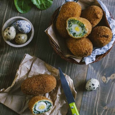 Uova alla scozzese di verdure impanate e fritte, tagliate a meta con cuore di uovo di quaglia e spinaci