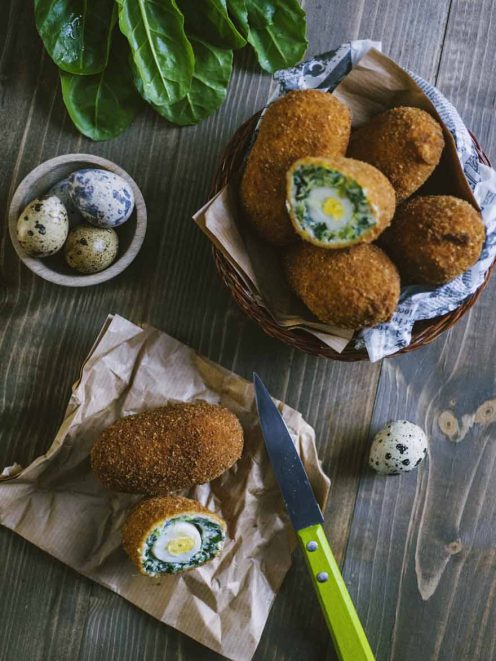 Uova alla scozzese di verdure impanate e fritte, tagliate a meta con cuore di uovo di quaglia e spinaci