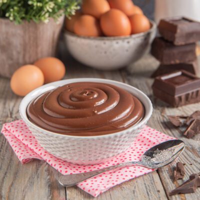 Crema pasticcera al cioccolato servita in ciotola con superficie liscia a spirale