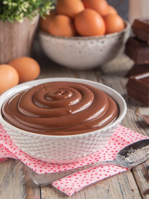 Crema pasticcera al cioccolato servita in ciotola con superficie liscia a spirale