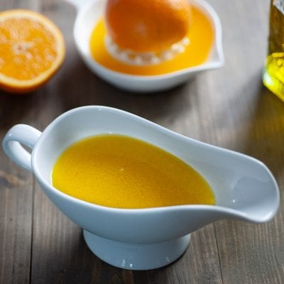 Orangette in salsiera con arance fresche spremute sullo sfondo