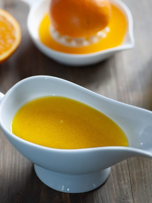 Orangette in salsiera con arance fresche spremute sullo sfondo