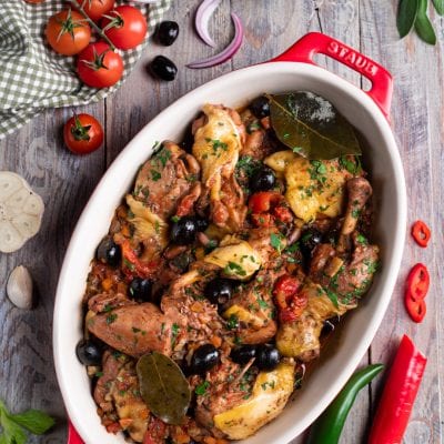 Pollo alla cacciatora con olive nere, pomodoro, foglie di alloro e prezzemolo tritato