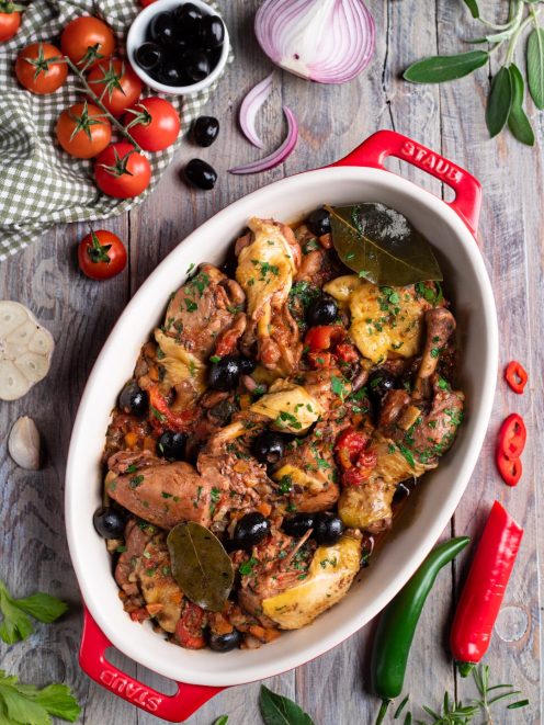 Pollo alla cacciatora con olive nere, pomodoro, foglie di alloro e prezzemolo tritato