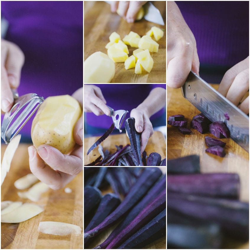 Patate pelate e tagliate a tocchetti accanto a carote viola pelate e ridotte a pezzi sul tagliere