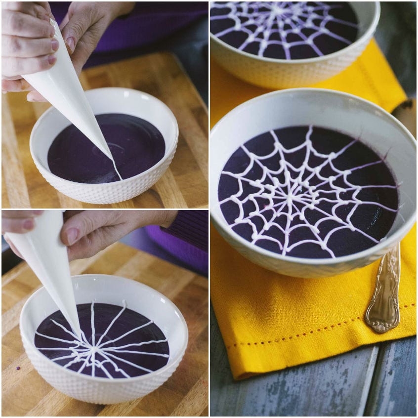 Decorazione a ragnatela disegnata con sac-à-poche di yogurt sulla vellutata viola