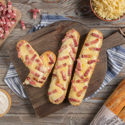 Croque baguette con formaggio filante e cubetti di pancetta gratinati su pane croccante