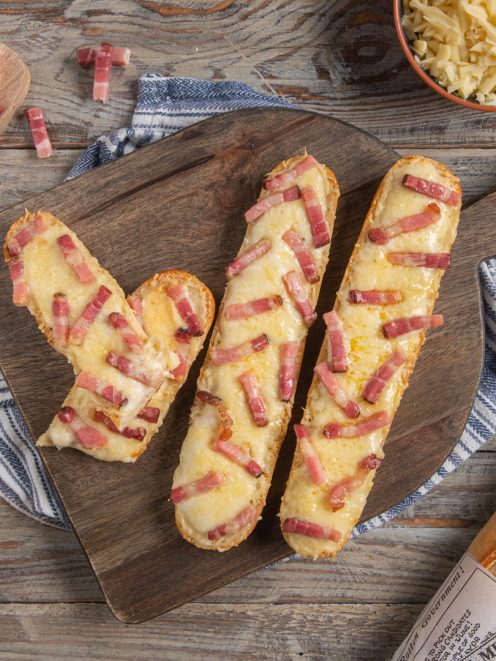 Croque baguette con formaggio filante e cubetti di pancetta gratinati su pane croccante
