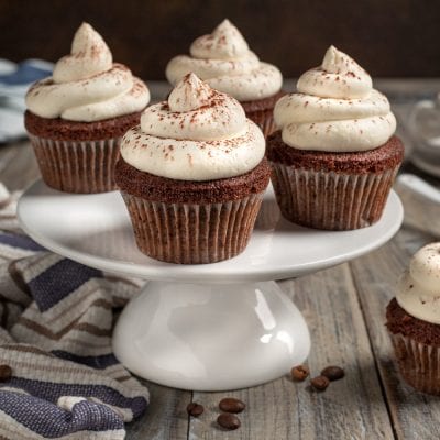 Cupcake cappuccino al cioccolato con ciuffo di crema e spolverata di cacao
