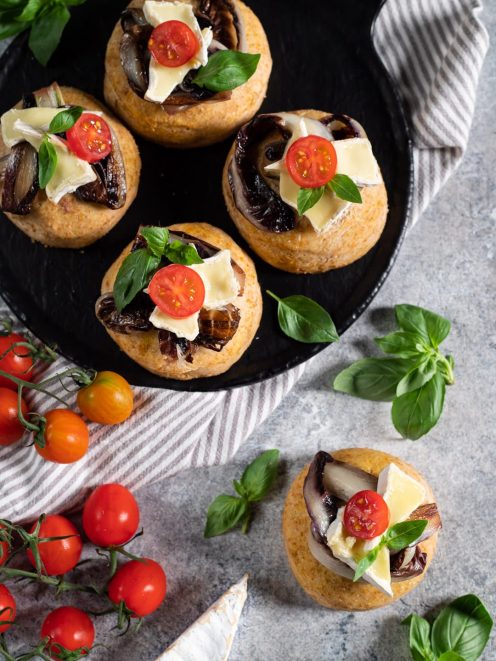 Focaccine integrali con radicchio arrostito, brie e pomodorini ciliegino guarnite con foglie di basilico