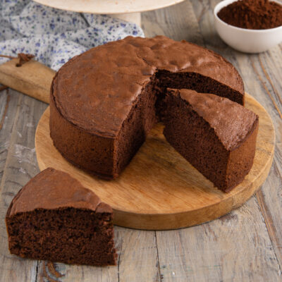 Pan di Spagna al cacao con una fetta tagliata che mostra la mollica soffice e compatta