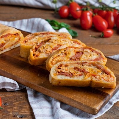 Rotolo di pizza affettato con ripieno di salsa, salumi e formaggio filante