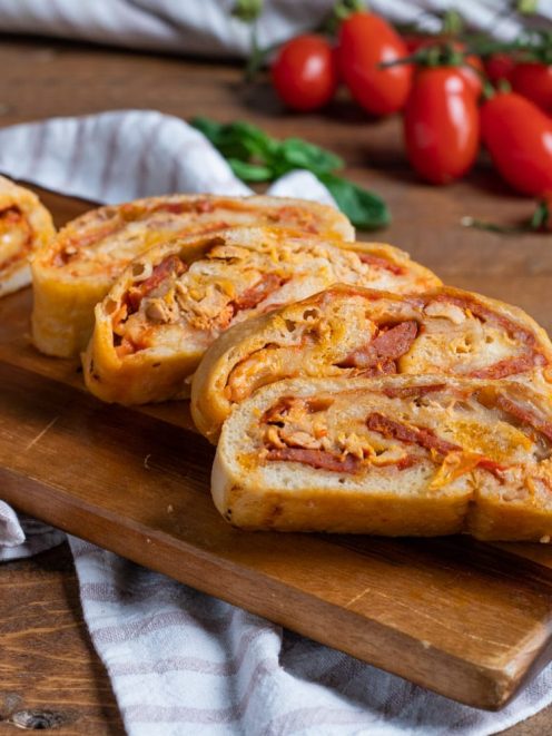 Rotolo di pizza affettato con ripieno di salsa, salumi e formaggio filante