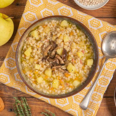 Zuppa di orzo con funghi e mele, patate a cubetti e brodo dorato con pepe nero