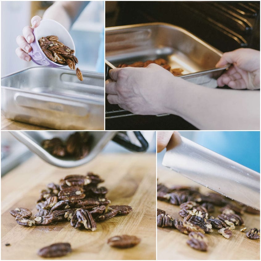 Noci pecan tostate rovesciate su un tagliere di legno e tritate grossolanamente con un coltello