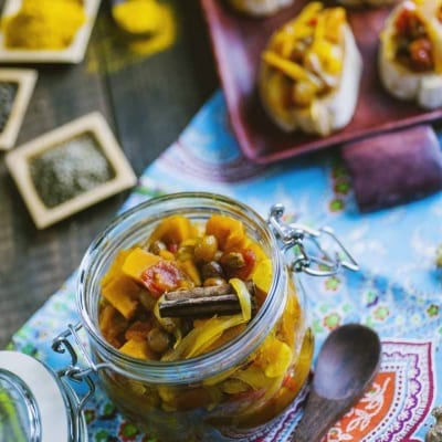 Chutney speziato con zucca e cannella in vasetto di vetro, servito su crostini di pane