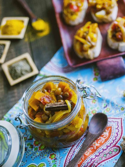 Chutney speziato con zucca e cannella in vasetto di vetro, servito su crostini di pane