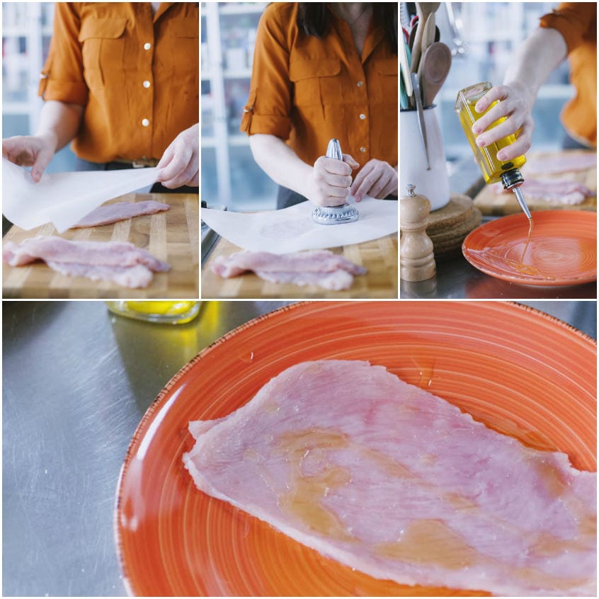 Fetta di petto di tacchino battuta tra fogli di carta forno e condita con un filo d'olio