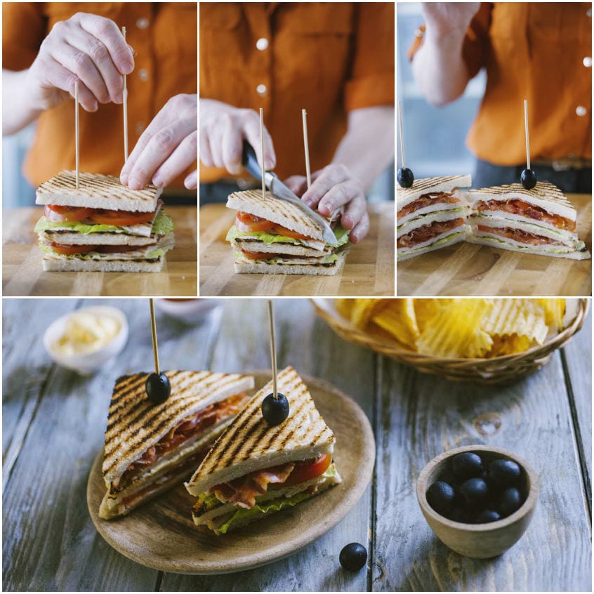Stecchini con oliva fissano il club sandwich prima di tagliarlo a triangoli con il coltello