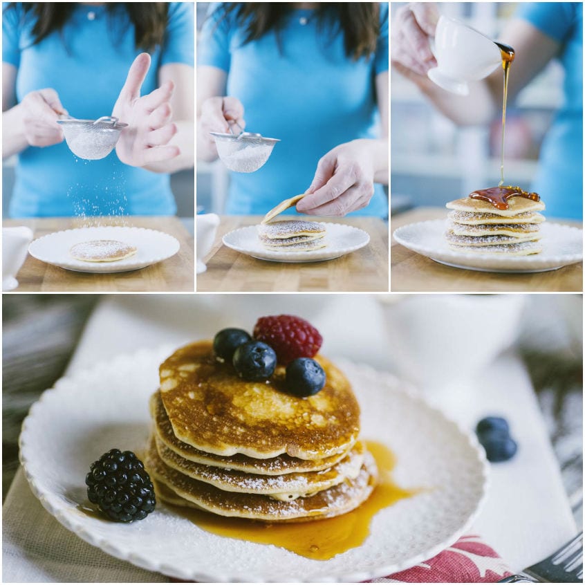 Sciroppo d'acero versato su una torretta di pancakes spolverati di zucchero a velo