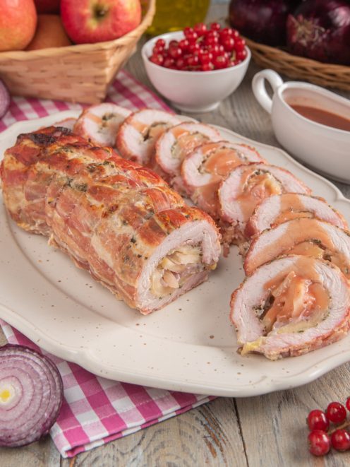 Arrotolato di maiale con mele e cipolle affettato e nappato con salsa al fondo di cottura