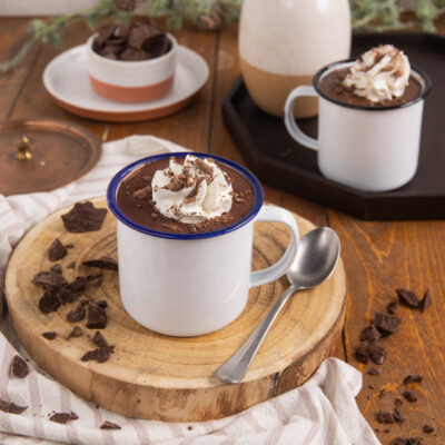 Cioccolata calda con panna montata e scaglie di cioccolato fondente in tazza smaltata