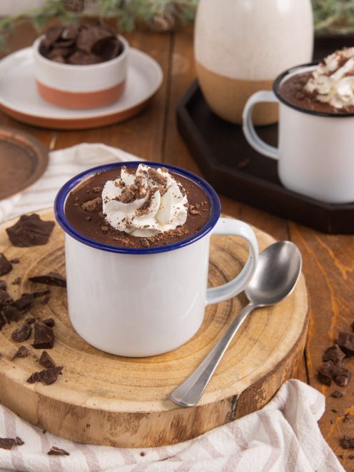 Cioccolata calda con panna montata e scaglie di cioccolato fondente in tazza smaltata