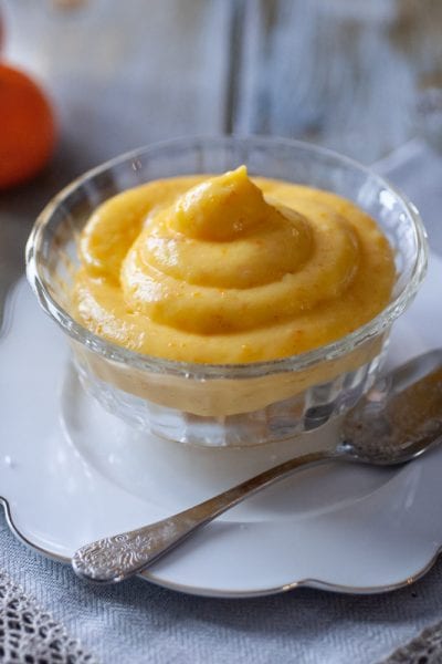 Crema pasticcera al mandarino servita in coppetta di vetro con cucchiaino d'argento