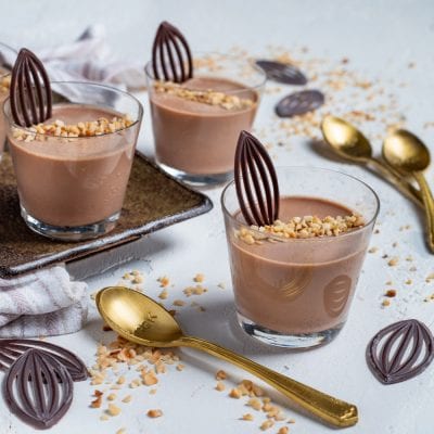 Cremoso al gianduia servito in bicchieri con granella di nocciole e decorazioni di cioccolato fondente