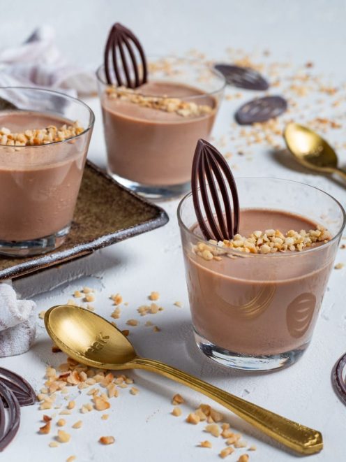 Cremoso al gianduia servito in bicchieri con granella di nocciole e decorazioni di cioccolato fondente