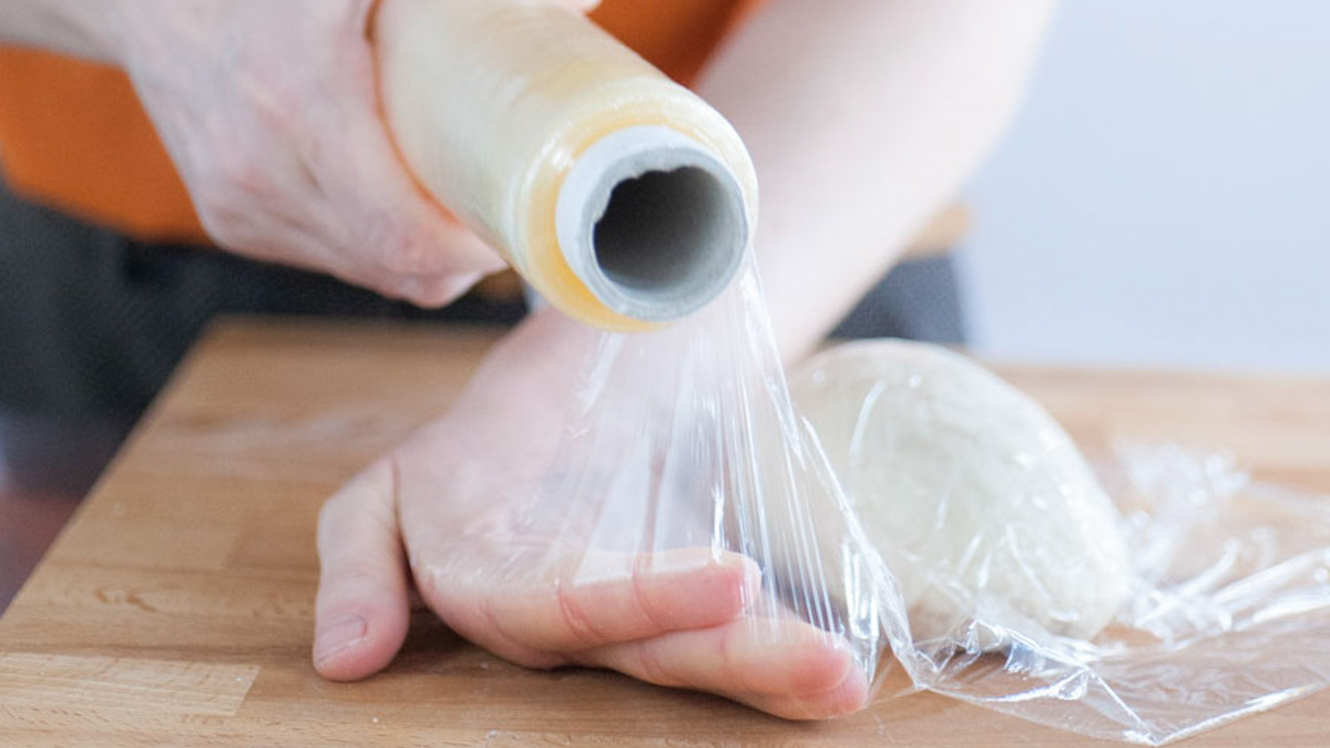 Panetto di pasta fresca avvolto con pellicola trasparente per il riposo