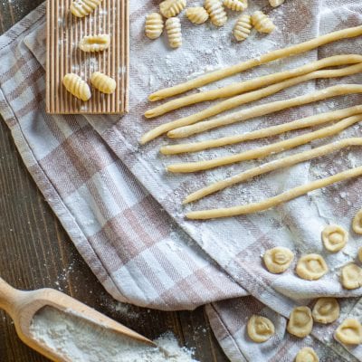 Pasta fresca di semola cruda: cavatelli rigati, spaghetti alla chitarra e orecchiette disposti su un canovaccio infarinato