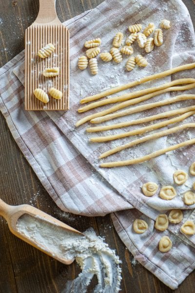 Pasta fresca di semola cruda: cavatelli rigati, spaghetti alla chitarra e orecchiette disposti su un canovaccio infarinato