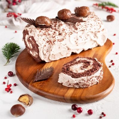 Tronchetto di Natale con crema di marroni, ricoperto di panna e scaglie di cioccolato