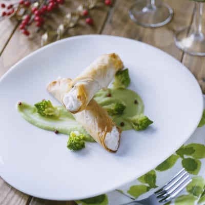 Cannoli croccanti di pasta fillo ripieni di baccalà mantecato su crema di broccolo romano e pepe rosa