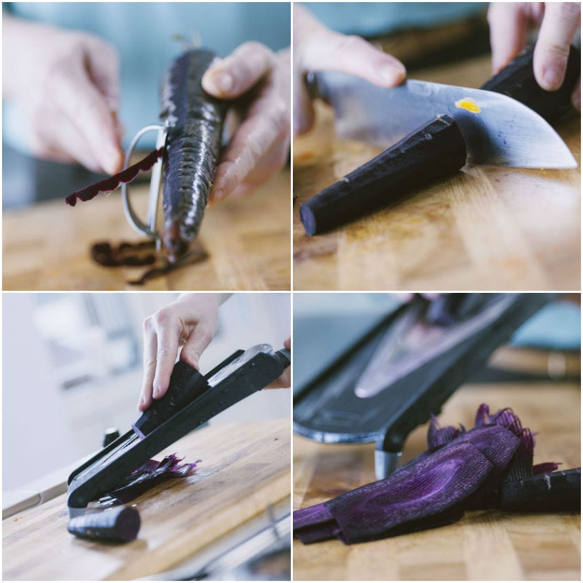 Mani che pelano e affettano carote viola su un tagliere di legno