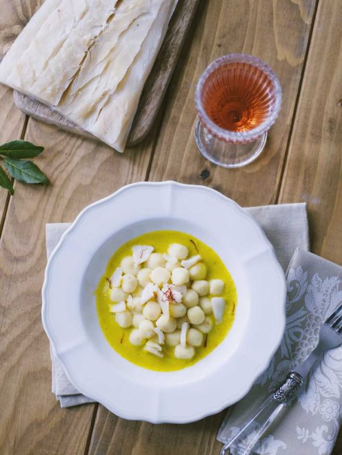 Gnocchetti di baccalà in salsa di cipollotti e zafferano, guarniti con scaglie di baccalà