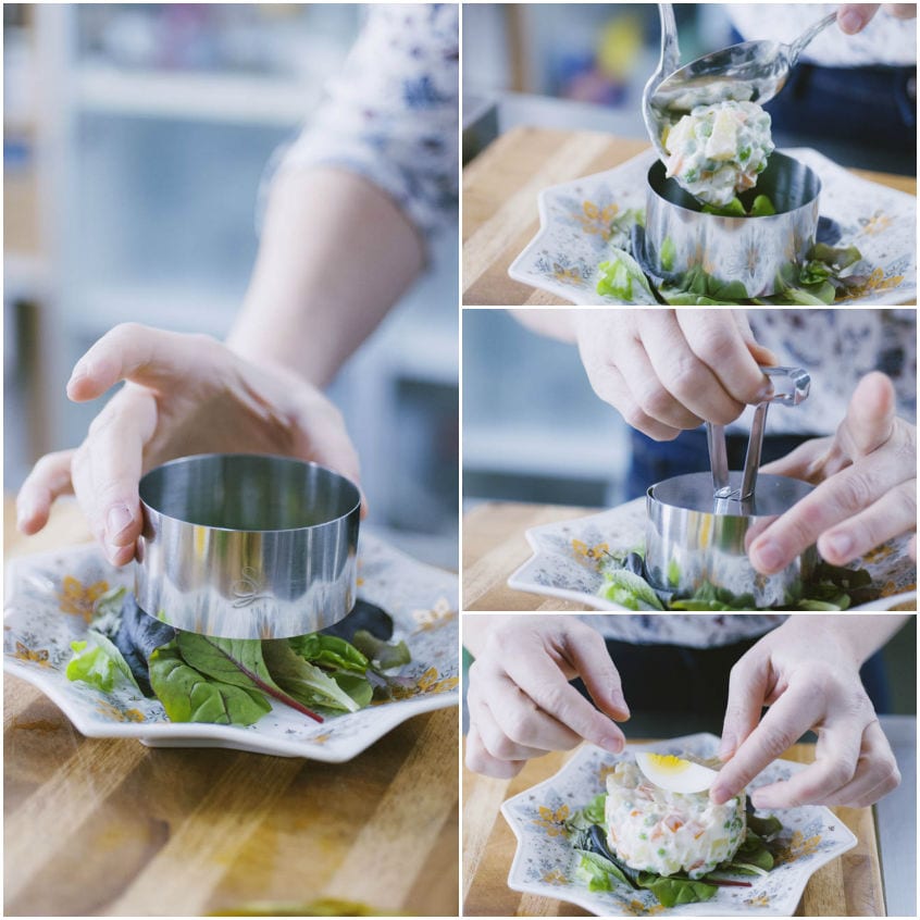 Composizione dell'insalata russa con coppapasta cilindrico su letto di insalatina